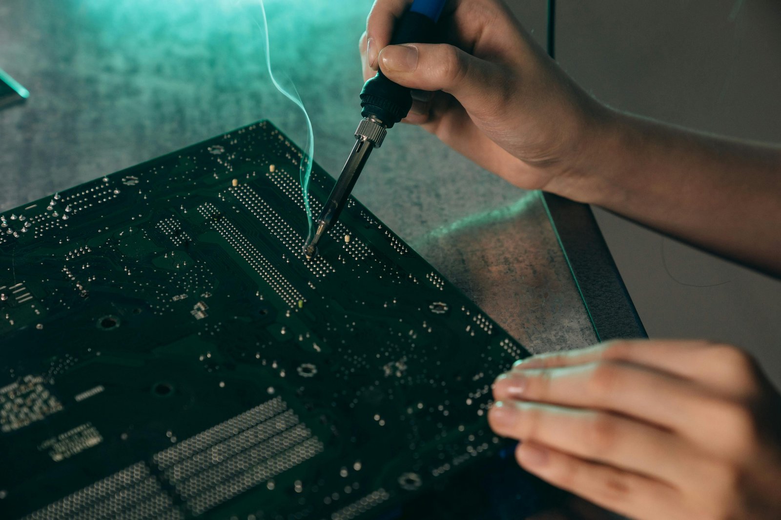 Technician repairing a PC motherboard